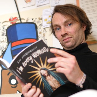 Porträt Junger Mann hat einen Comic in der Hand