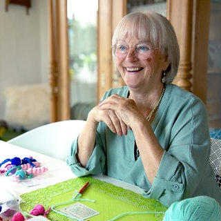 Strahlend lacht die 78-jährige Carin in die Kamera. Schon über 3.000 Glücksbringer hat sie gehäkelt und verschenkt.