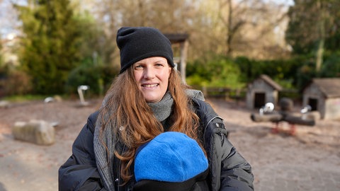 Frau steht auf Kinderspielplatz