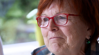 Maria aus Tübingen-Kilchberg überlebt einen Herzinfarkt dank Nachbarn. Sie trägt eine rote Brille und schaut gerührt.