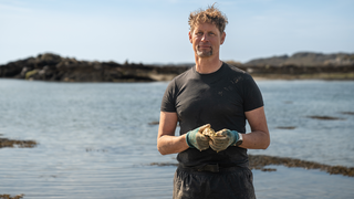Lars ist Austernfarmer auf einer schottischen Insel und hält eine Auster in der Hand.