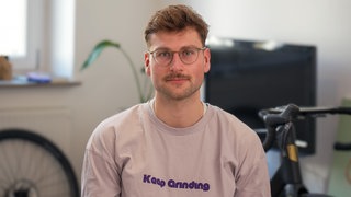 Jona lebt seit 14 Jahren mit Morbus Crohn. Trotz der Erkrankung trainiert er für einen Extrem-Triathlon. Stolz grinst er in die Kamera. 