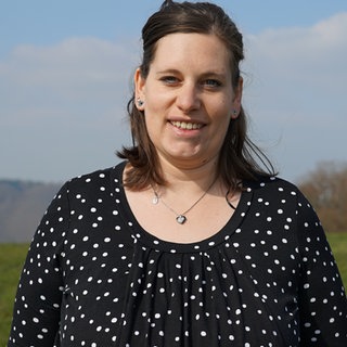 Junge Frau lächelt in Kamera