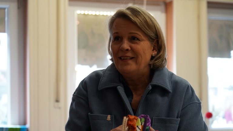 Charlotte greift mit beiden Händen einen bunten Wohlfühlbeutel.