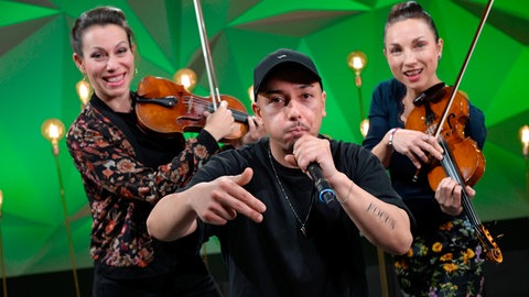 Beatboxer Robert Robeat Wolf mit dem Violinduo TheTwiolins auf der Bühne
