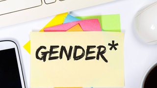 Zettel mit dem Wort Gender*, daneben ein Handy und eine Computermaus
