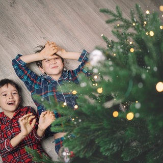 Zwei Kinder unter dem Weihnachtsbaum