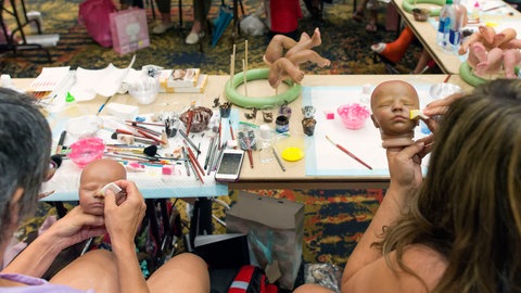 Teilnehmerinnen eines Workshops bemalen ihre Reborn-Babys