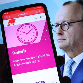 Auf einem Smartphone wurde die Website vom Deutschen Gewerkschaftsbund (DGB) mit Informationen zur Teilzeitarbeit geöffnet. Dahinter wurde auf einem Laptop die Website der Partei CDU mit dem Konterfei von Bundeskanzler Friedrich Merz geöffnet. 