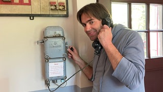 Andreas Kurth am ehemaligen Notfalltelefon des Museumsbahnhofs Üxheim-Ahütte