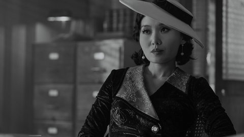 Cat Hardy (Li Jun Li) mit modischem Hut im Büro des Privatdetektiven Ben Reilly (Spider-Noir)
