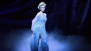 Musical-Darstellerin Ann Sophie ist Königin Elsa in dem Musical Eiskönigin. Sie steht in ihrem Kostüm auf der Bühne.