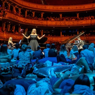 Besucher vom Eröffnungsfest "24h Opernhaus" am 20.09.2025 verfolgen auf der Bühne vom Opernhaus Zürich einen Auftritt von Mezzosopranistin Siena Licht Miller.