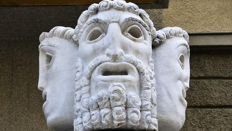 Statue mit Theatermasken am Eingang des Salzburger Festspielhauses