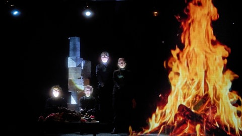 Theaterszene mit einer Projektion eines Lagerfeuers
