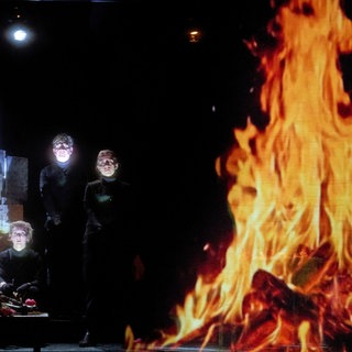 Theaterszene mit einer Projektion eines Lagerfeuers