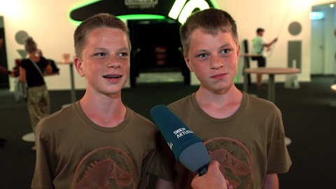 Zwei Teenager bei der Premiere von Jurassic World in Mannheim. Sie geben ein Interview.