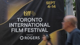 2025 Toronto International Film Festival (TIFF) Leute laufen am Werbebanner vorbei 