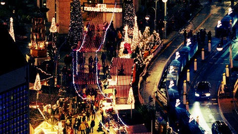 "Der Anschlag": Totale von weihnachtlich geschmückten Buden und Lichterketten