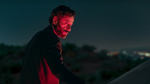 Eghbal (Ebrahim Azizi) wird im Rücklicht eines Autos rot beleuchtet.