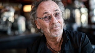 Moderator Hugo Egon Balder lächelt in die Kamera | Hugo Egon Balder und seine großen Shows der 90er