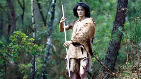 Steinzeitjäger im Wald der Nacheiszeit auf Jagd, lebensnahe prähistorische Darstellung im Parc de Prehistoire in Rochefort-en Terre in der Bretagne 