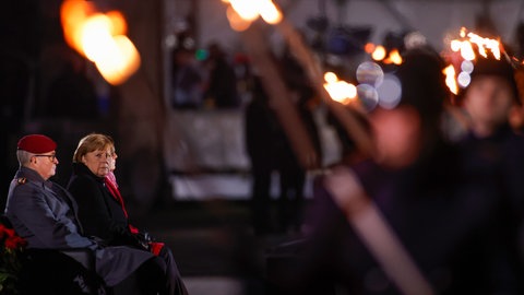 Bundeskanzlerin Angela Merkel (Mitte) verfolgt neben Verteidigungsministerin Annegret Kramp-Karrenbauer (rechts, beide CDU) und dem Generalinspekteur der Bundeswehr, General Eberhard Zorn, ihre Verabschiedung durch die Bundeswehr. Mit einem Großen Zapfenstreich wird Kanzlerin Merkel gegen Ende ihrer Regierungszeit nach 16 Jahren verabschiedet.