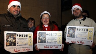 Menschen zeigen ihre El Gordo-Lotterielose, während sie auf den Beginn der Ziehung im Königlichen Theater in Madrid, Spanien, am 22. Dezember 2015 warten. Die traditionelle spanische Weihnachtslotterie El Gordo.