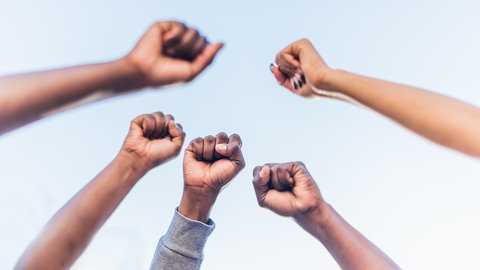 Fäuste von BIPoC in die Luft gestreckt