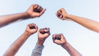 Fäuste von BIPoC in die Luft gestreckt