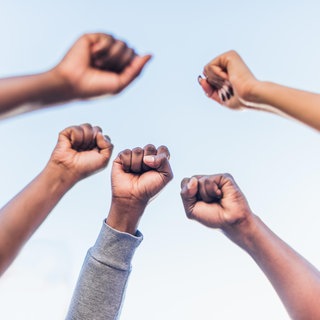 Fäuste von BIPoC in die Luft gestreckt