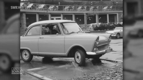 Frau fährt mit Ihrem Auto vom Parplatz