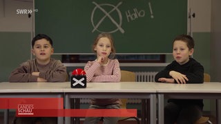 drei Kinder vor einer Schultafel