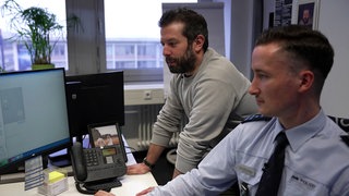 Zwei Polizisten arbeiten am Computer