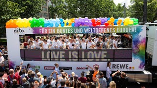 Teilnehmer ziehen 2016 bei der Christopher-Street-Day-Parade in Köln auf einem Wagen mit den Logos von Sponsoren durch die Stadt.