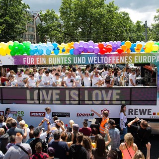 Teilnehmer ziehen 2016 bei der Christopher-Street-Day-Parade in Köln auf einem Wagen mit den Logos von Sponsoren durch die Stadt.