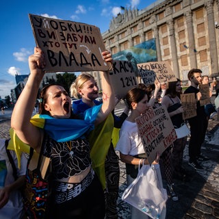 Eine junge Frau trägt ein Plakat bei einer Demonstration gegen das neue Gesetz