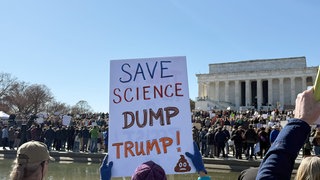 Ein Schild mit der Aufschrift «Save Science - Dump Trump!» (Rettet die Wissenschaft - Weg mit Trump!) ist bei einer Kundgebung von Wissenschaftlern und Forschern gegen Kürzungen bei den Etats und Stellenstreichungen am Lincoln Memorial zu sehen.