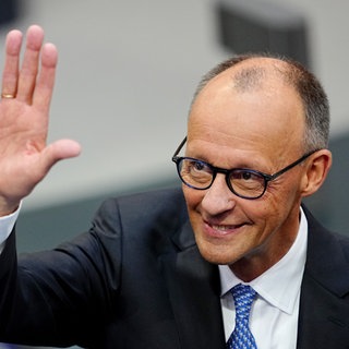 Der designierte Bundeskanzler Friedrich Merz (CDU) winkt im Bundestag vor der Kanzlerwahl.