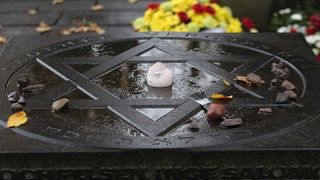 Jüdischer Friedhof Am Lindenpark in Rostock: Ein übergroßer Davidstern im Mittelpunkt, der mit einer Kerze geschmückt ist. Der Friedhof wurde um 1831 angelegt und war der erste stätische Friedhof der Stadt. 