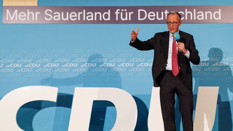 CDU-Kanzlerkandidat Friedrich Merz spricht in ein Mikrofon vor dem Logo der CDU