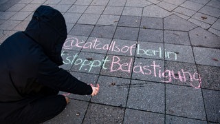 Studentin schreibt mit Kreide @catcallsofberlin ... #stoppt Belästigung» auf einem Bürgersteig. Danach fotografiert die 21-Jährige ihr Werk und veröffentlicht es auf der Instagram-Seite «catcallsofberlin». Archivfoto.