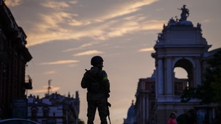 Ein ukrainischer Soldat sichert den Besuch der damaligen deutschen Staatsministerin für Kultur und Medien Roth (Bündnis 90Die Grünen) bei ihrem Besuch der Altstadt der ukrainischen Hafenstadt Odessa am Schwarzen Meer (Juni 2022). 