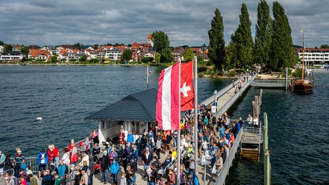 Viele Menschen drängeln sich auf dem Schiffsanlegesteg in Hagnau