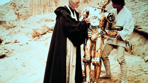 Alec Guinness als Jedi-Ritter Obi Wan Kenobi (links), C-3PO und Mark Hamill als Luke Skywalker in „Krieg der Sterne“, von 1977.