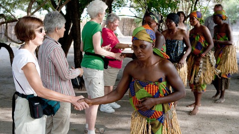 Frauen im Dorf Lizauli im Caprivi Streifen in Namibia begrüßen deutsche Touristen nach einer Vorführung traditioneller Tänze und Gesänge.