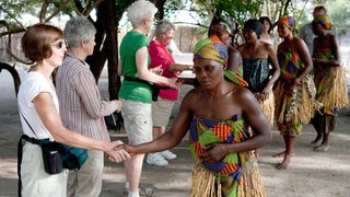 Frauen im Dorf Lizauli im Caprivi Streifen in Namibia begrüßen deutsche Touristen nach einer Vorführung traditioneller Tänze und Gesänge.