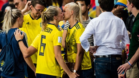 Zwei Frauen in gelbem Fussballtrikot küssen sich