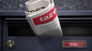 Die "Tageszeitung" ("taz") steckt in einem Briefkasten. Zukünftig wird unter der Woche keine Printausgabe der taz mehr in Briefkästen stecken, da sie Perspektivisch unter der Woche nur noch digital erscheinen soll.
