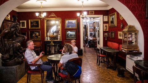 Die Innenräume des Antico Caffè Greco sind reich an Kunstwerken, Erinnerungsstücken und historischen Möbeln. Fotografien an den Wänden erzählen von der Geschichte des Lokals und seiner engen Verbindung zu Künstlern und Intellektuellen.